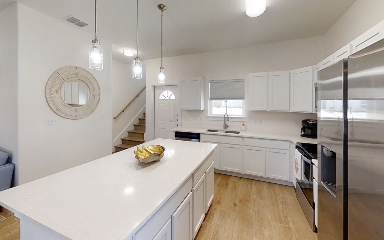 Your bright, modern kitchen offers gleaming quartz counters and stainless appliances, perfect for preparing meals in style.