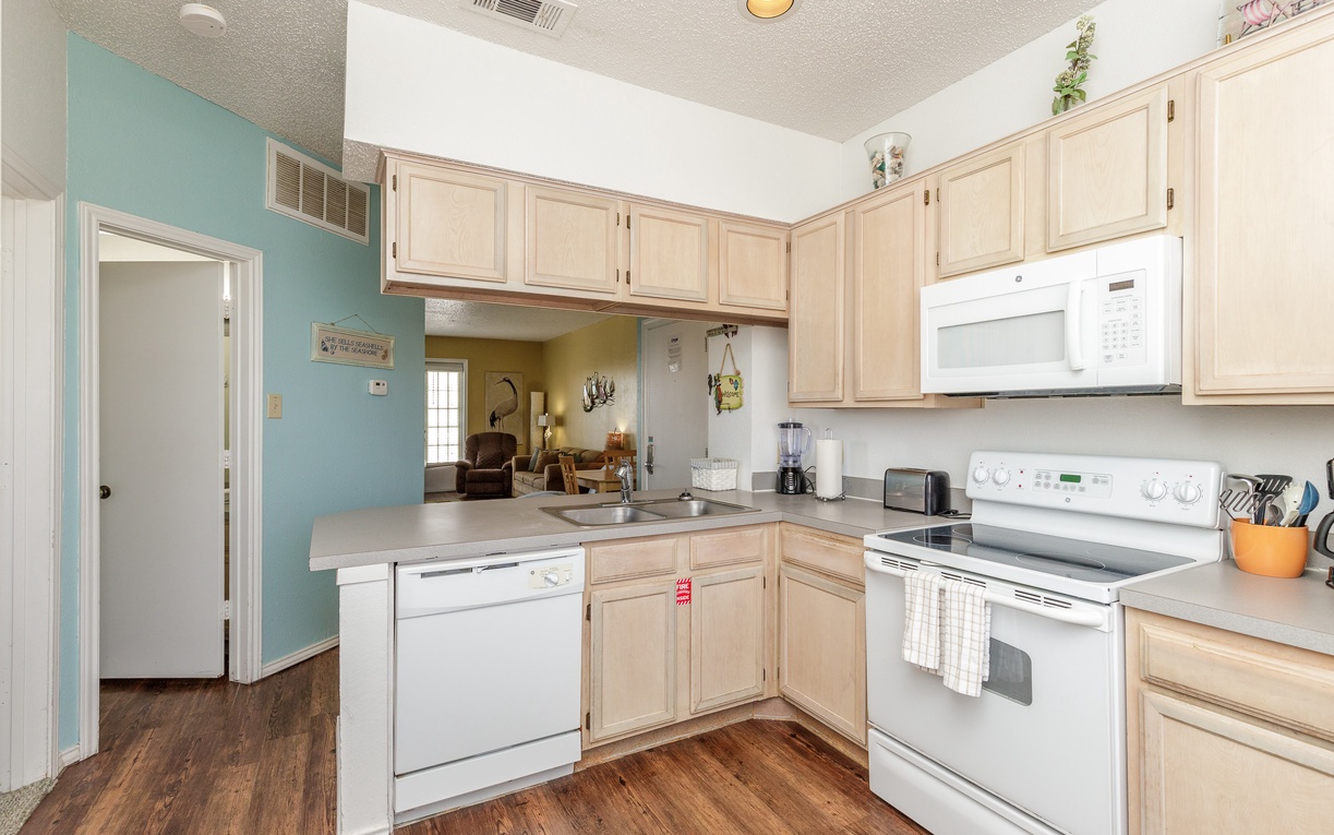 Your fully equipped kitchen features warm wood cabinets, modern appliances, and opens to the living area for easy entertaining.