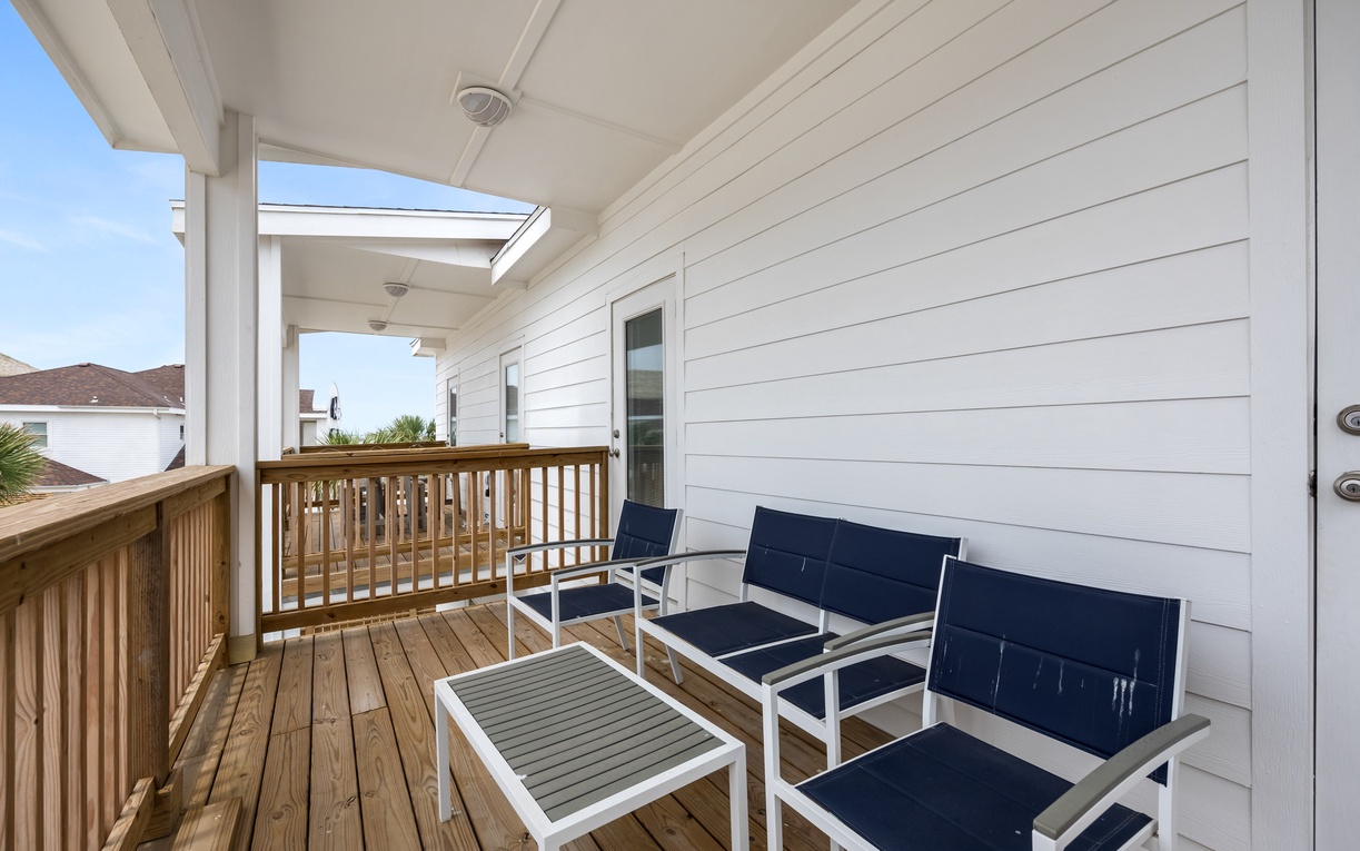 Unwind on your private covered balcony with comfortable seating and warm wood decking, perfect for morning coffee or evening relaxation.