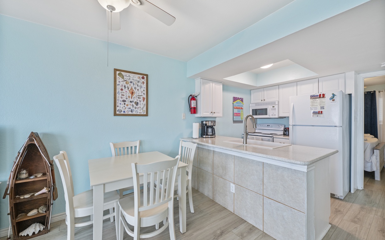 Prepare delicious meals in your fully equipped kitchen featuring granite counters, white cabinets, and a cozy dining nook perfect for morning coffee together.