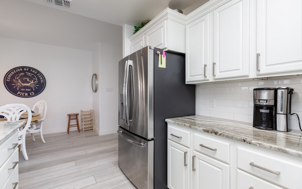 Your fully equipped kitchen features granite counters, stainless appliances, and crisp white cabinetry for effortless meal preparation during your stay.