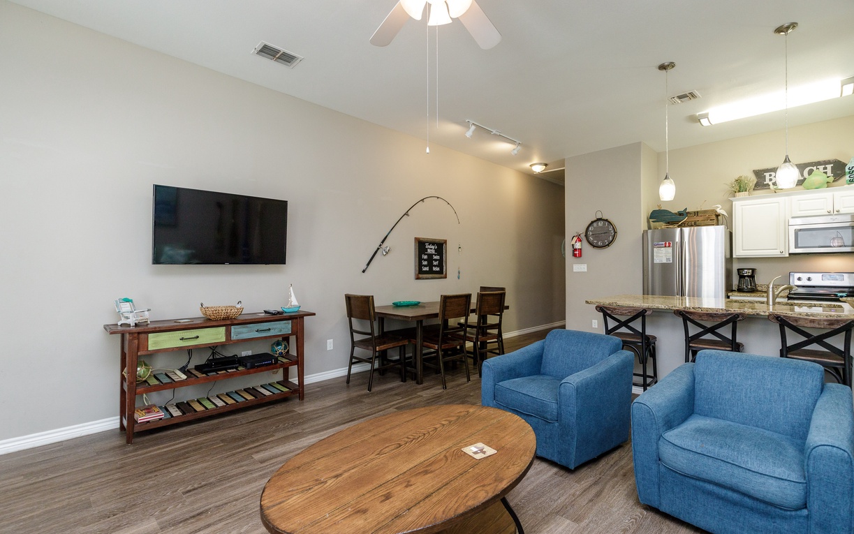 Relax in your spacious open-concept living area with comfortable seating, modern kitchen, and entertainment setup for memorable evenings together.