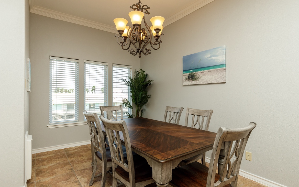 Gather around your elegant dining table where natural light streams through windows, creating the perfect setting for memorable meals together.