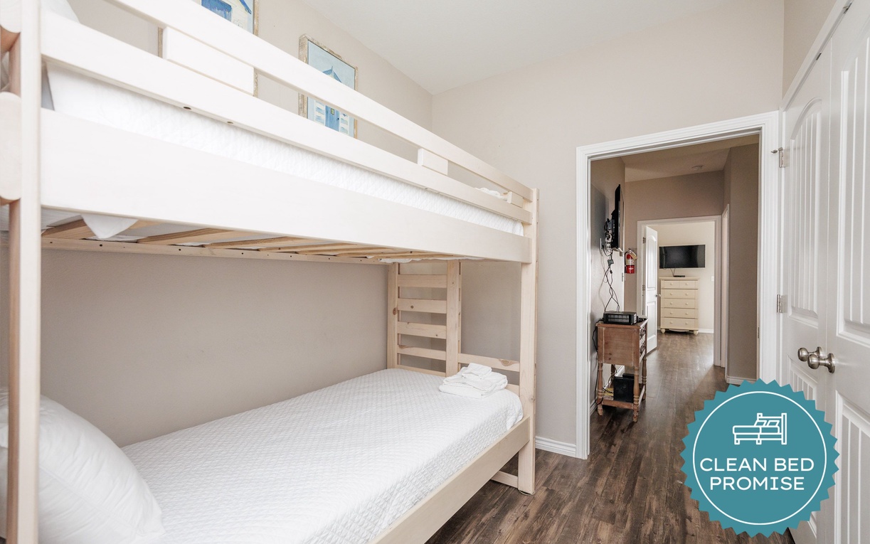 Cozy bunk beds with fresh linens make bedtime adventures for your family. This bright space connects to other rooms for easy access.