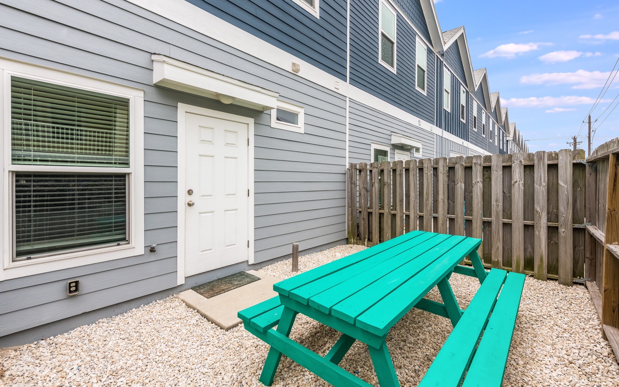 Step into your private backyard oasis with a bright turquoise picnic table perfect for morning coffee or evening meals outdoors.