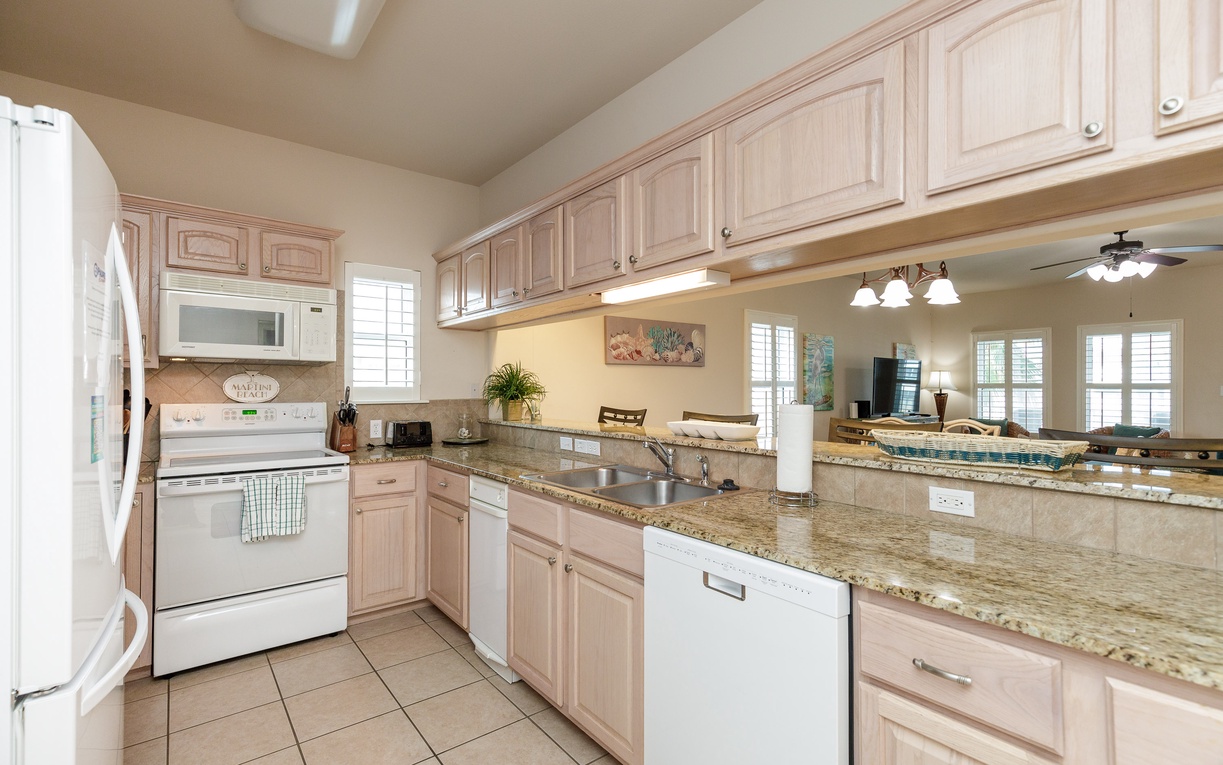 Cook memorable meals in your spacious kitchen with granite countertops, white appliances, and open bar perfect for morning coffee.