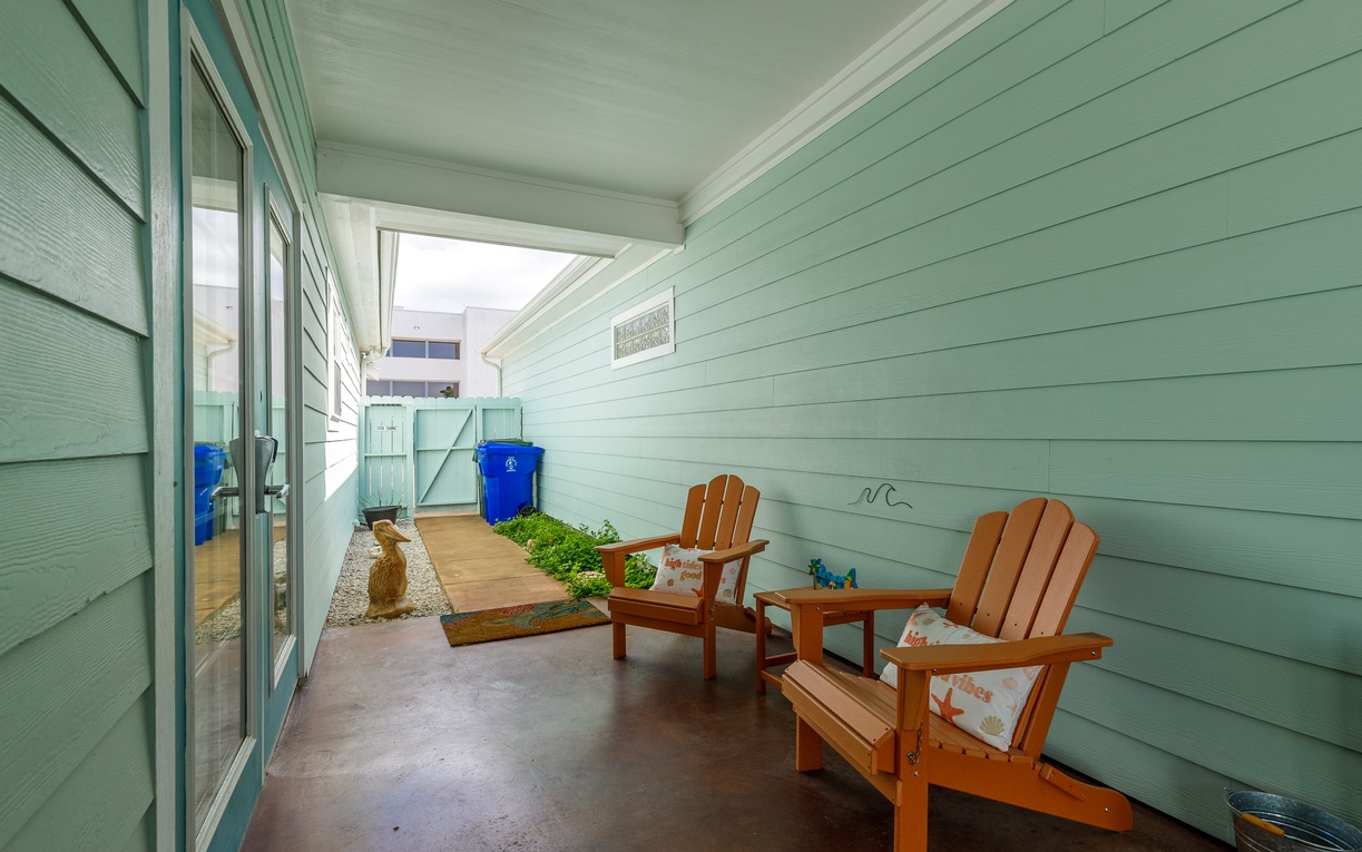 Your private covered patio offers the perfect spot to unwind in comfortable Adirondack chairs, surrounded by charming coastal-inspired details.