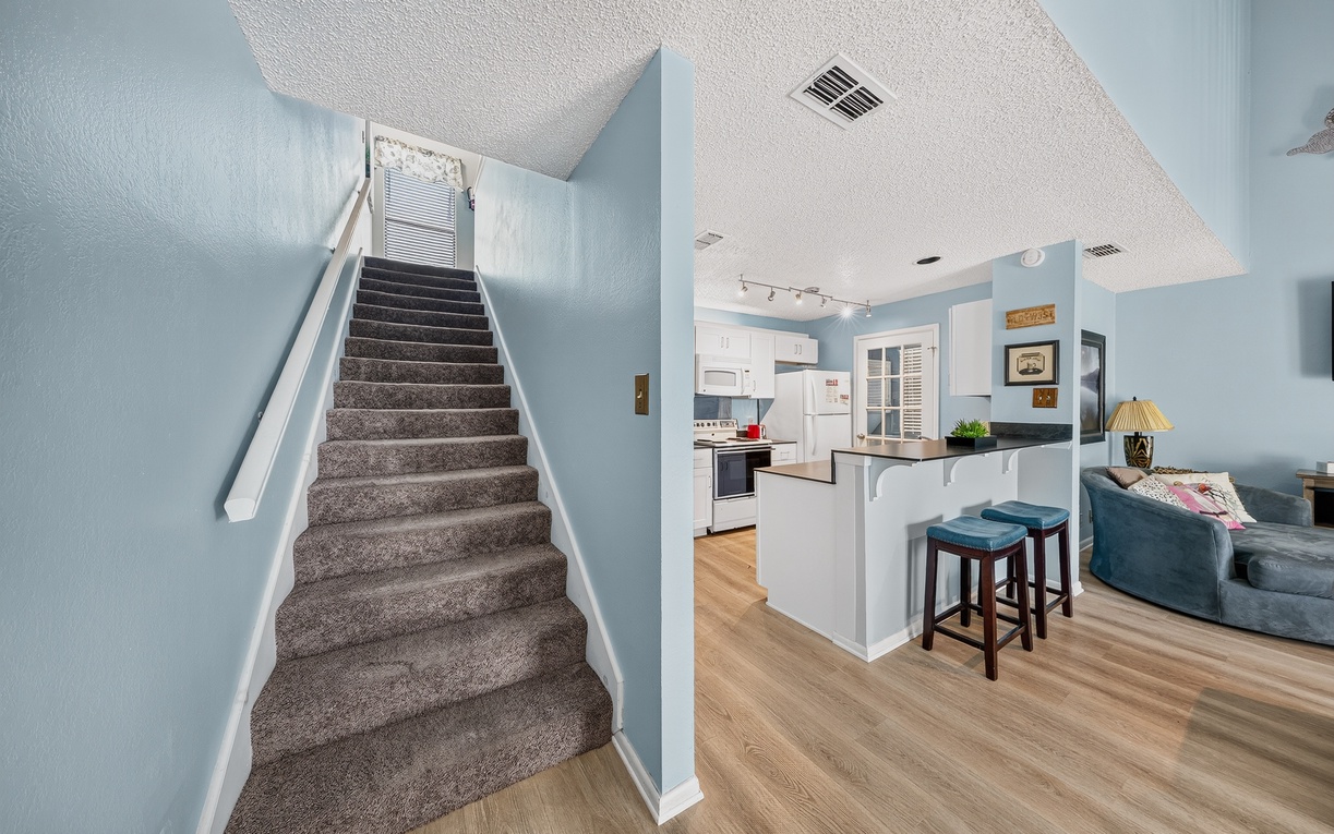 Your inviting open-concept space combines a fully equipped kitchen, comfortable living area, and bright stairway, perfect for preparing meals and relaxing after your adventures.