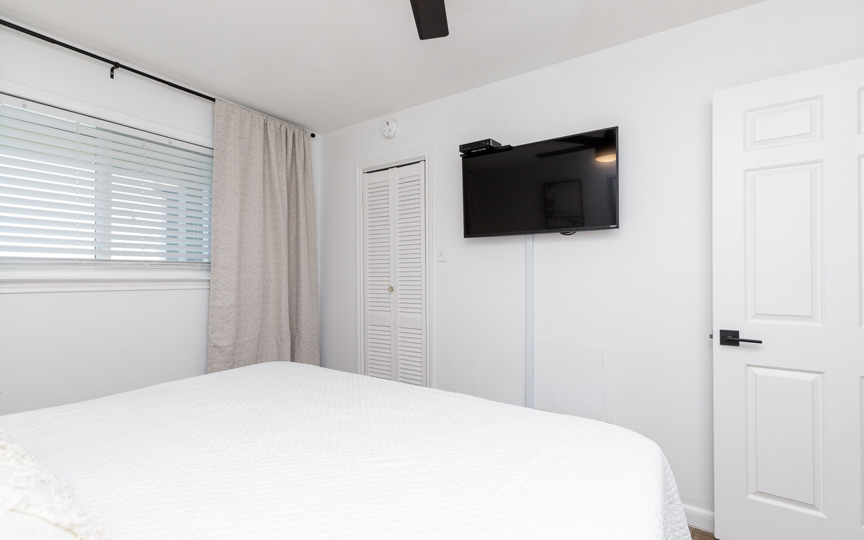 Sink into your plush king size bed while enjoying your favorite shows on the wall-mounted TV in this serene, light-filled bedroom.