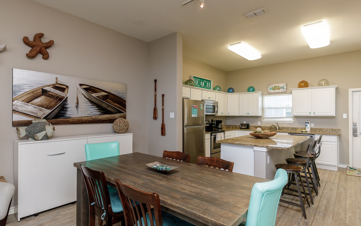 Gather around your spacious dining table while coastal art and nautical touches create the perfect beach house atmosphere.