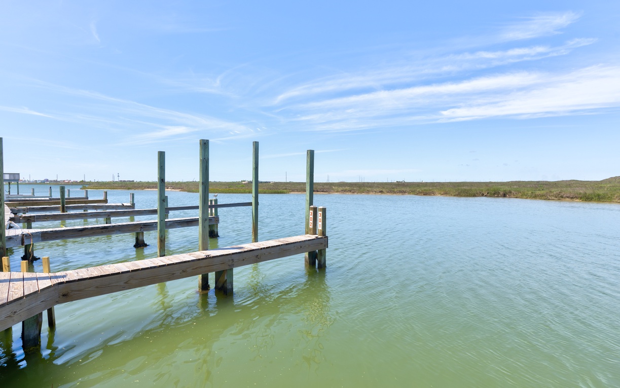 A private dock extends into calm waterways, surrounded by marshland and open skies—ideal for fishing, boating, or simply watching the day unfold from the water's edge.