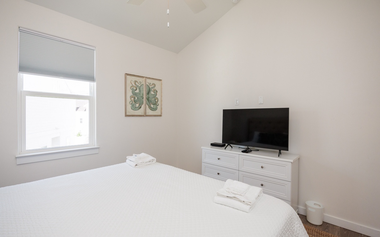 Unwind in your peaceful bedroom featuring crisp linens, modern TV entertainment, and natural light streaming through your window.