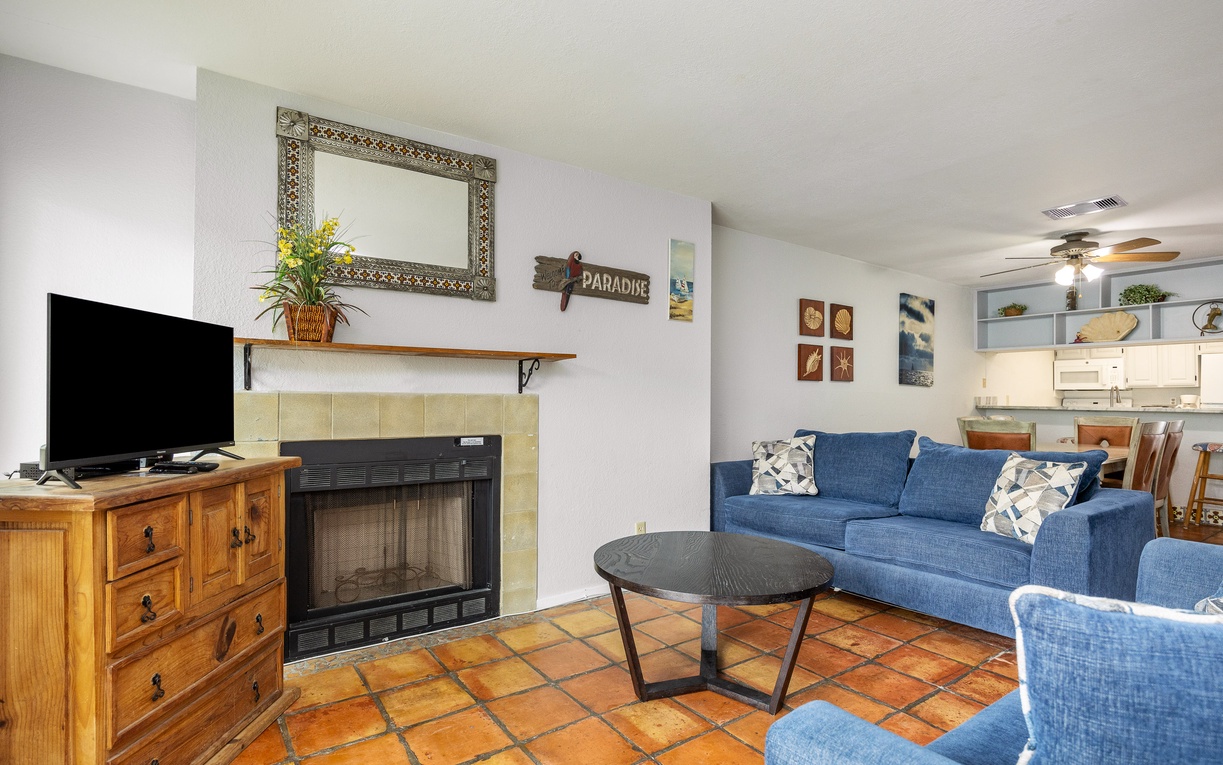 Relax in your cozy living space with comfortable blue seating, warm fireplace, and charming Southwest-inspired decor.