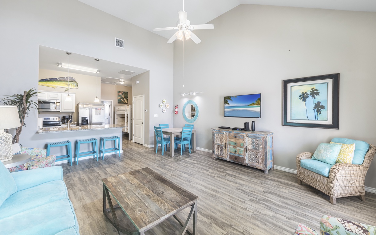 Relax in your bright, coastal-themed living space where beach blues and tropical touches create the perfect vacation vibe.