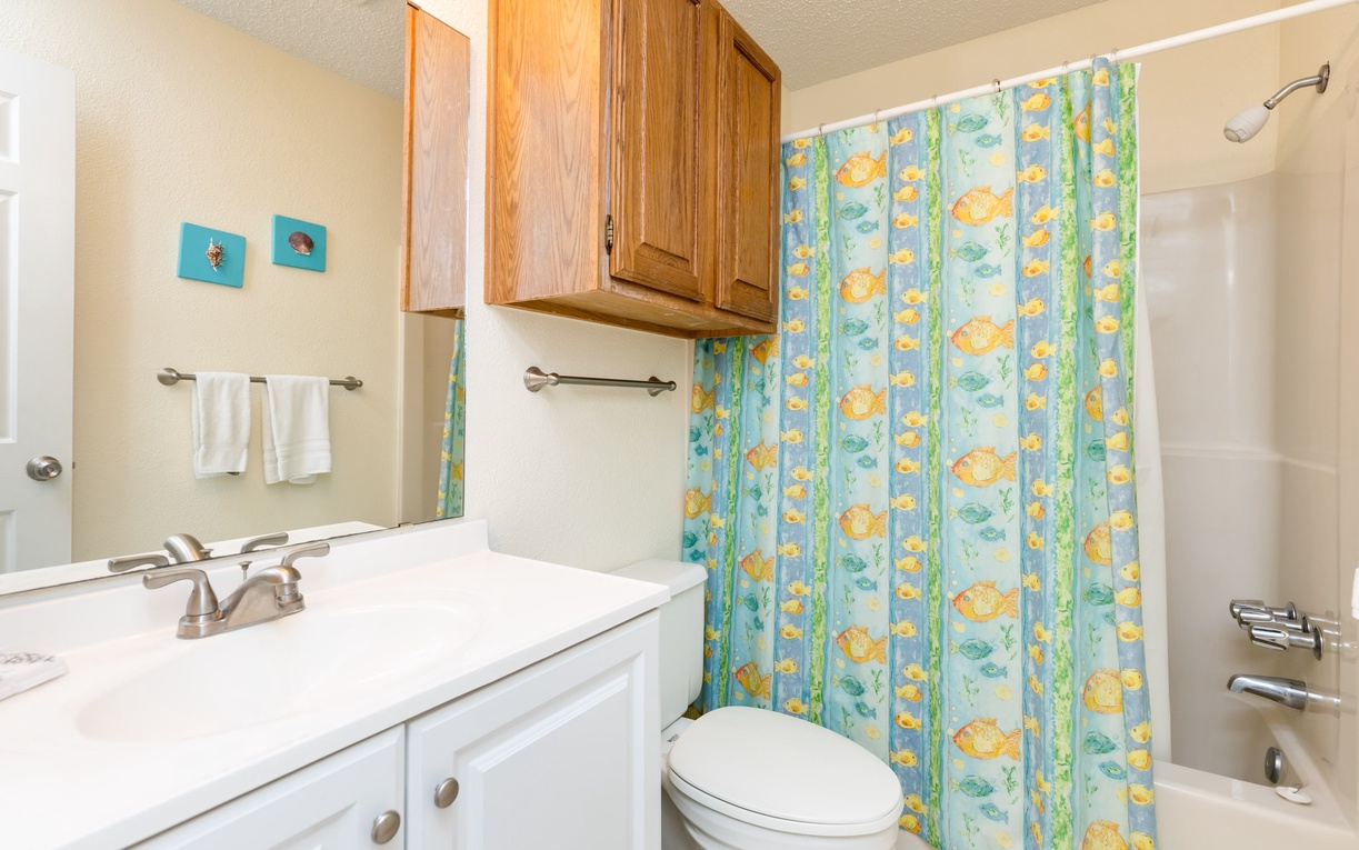 Refresh in your private bathroom featuring a cheerful fish-themed shower curtain that brings coastal charm to your daily routine.