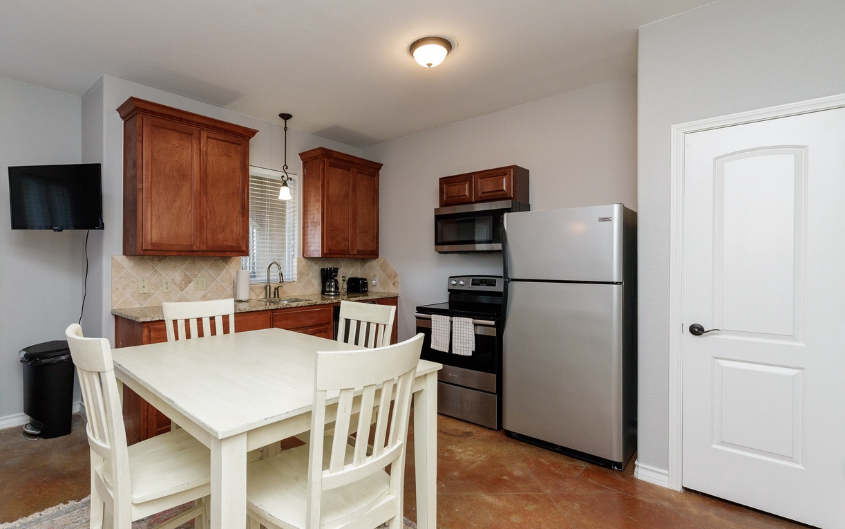 Your fully equipped kitchen features rich wood cabinets, granite counters, and modern appliances—perfect for preparing home-cooked meals during your stay.