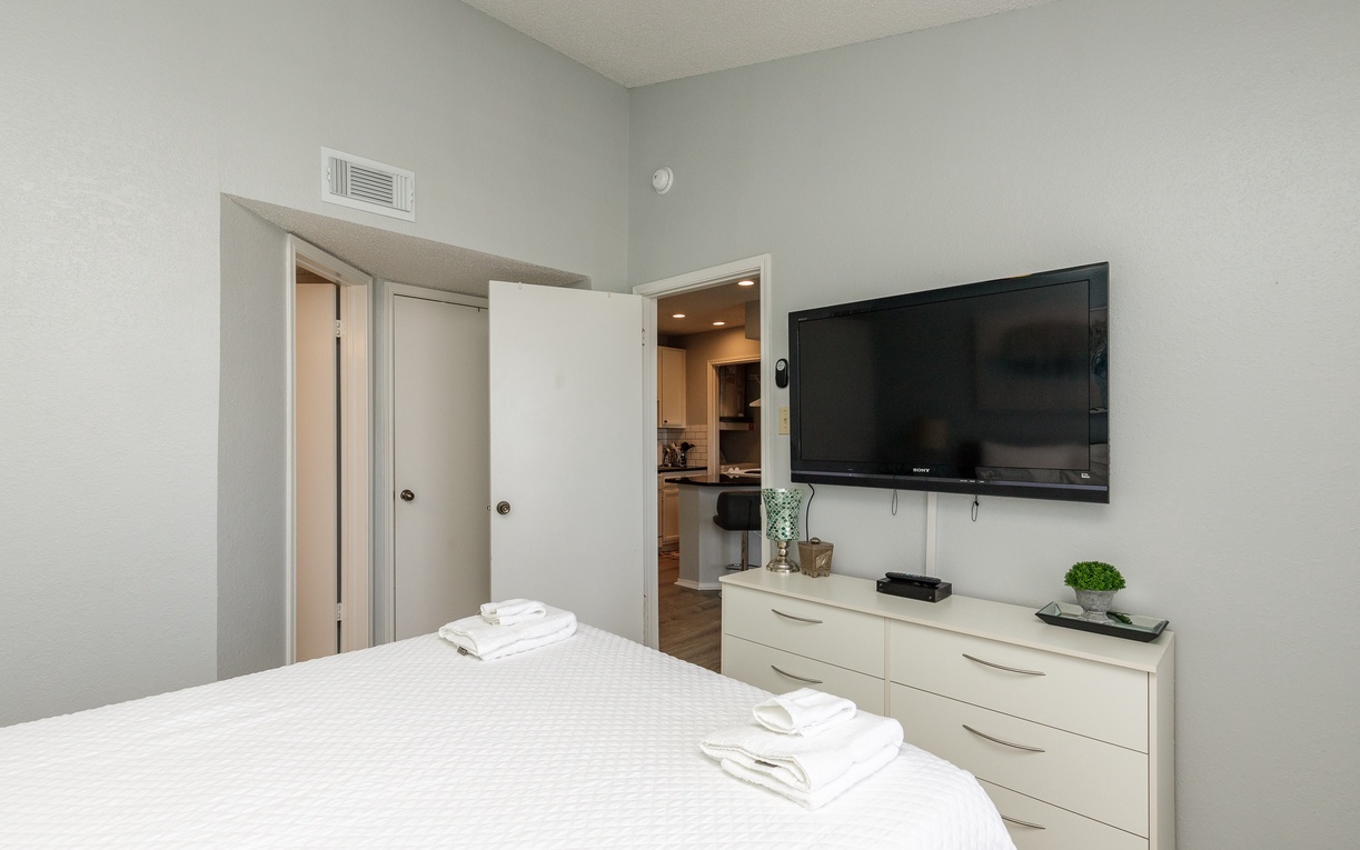Unwind in your modern bedroom featuring a queen size bed, crisp linens, and TV for ultimate comfort.