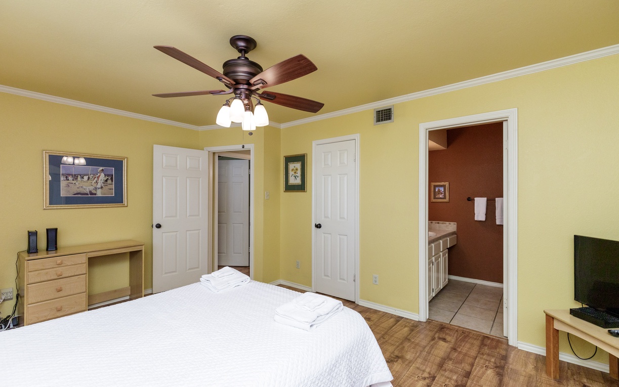 Unwind in your bright, airy bedroom with cheerful yellow walls and cozy furnishings. The ceiling fan keeps you cool while you rest.