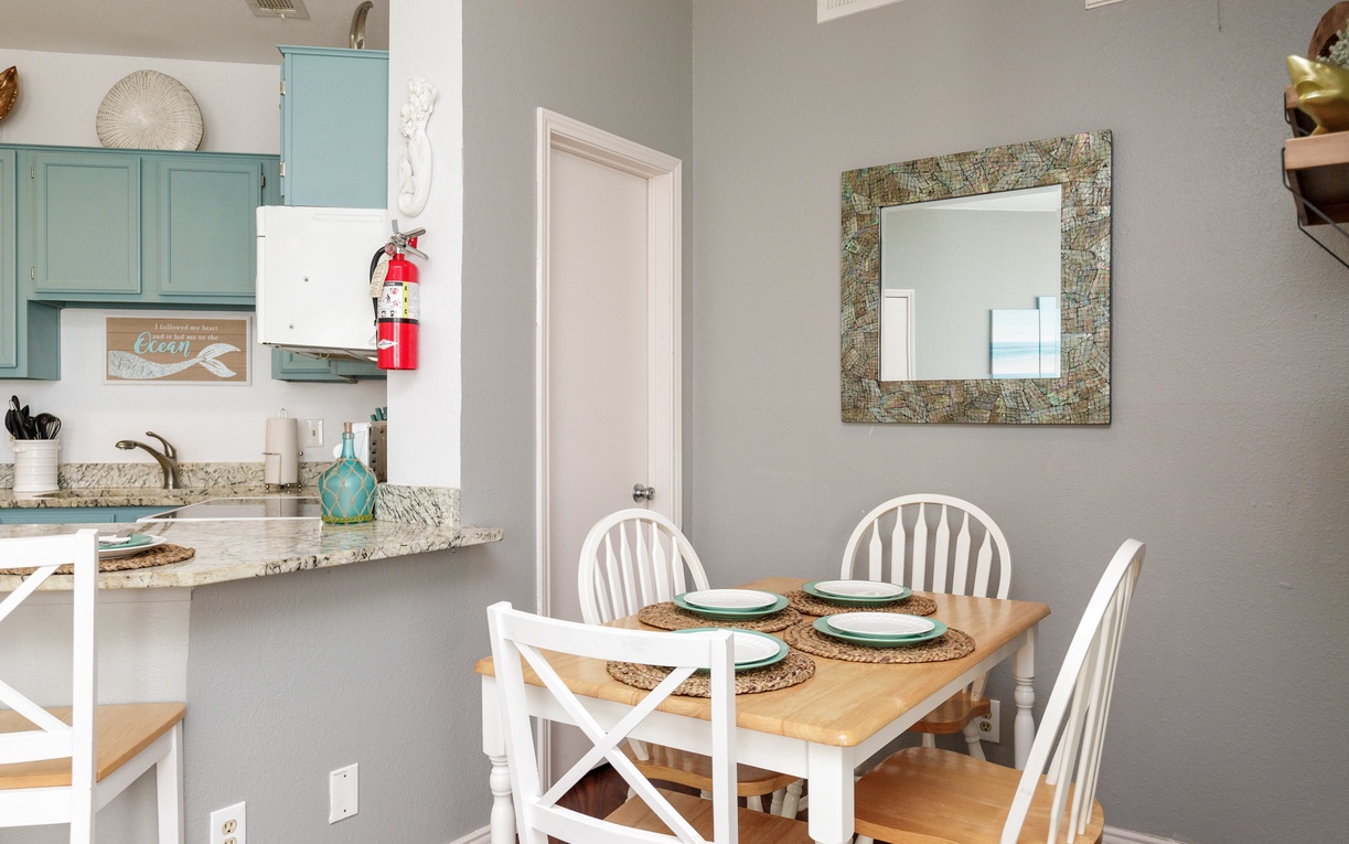 Your coastal-themed dining space invites shared meals with turquoise accents and charming nautical touches throughout.