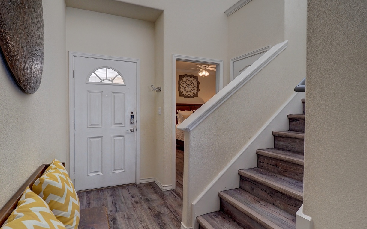 Step into your bright, welcoming entryway with soaring ceilings and natural light streaming through transom windows above.