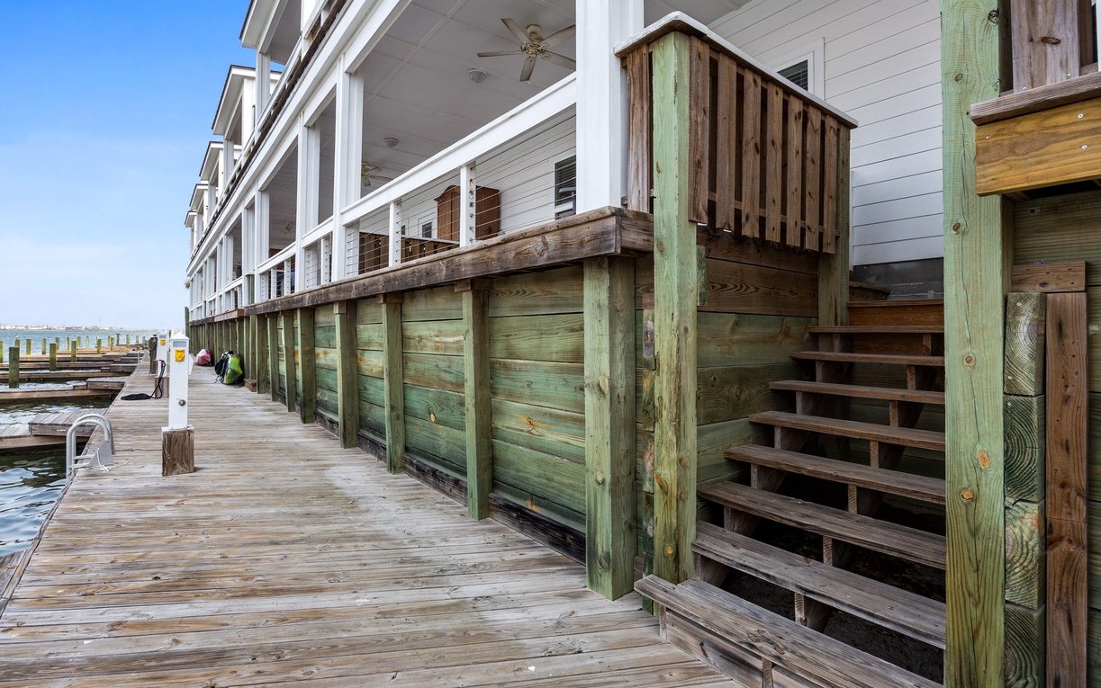 Waterfront property featuring elevated beach house design with covered porches and direct dock access for water activities.