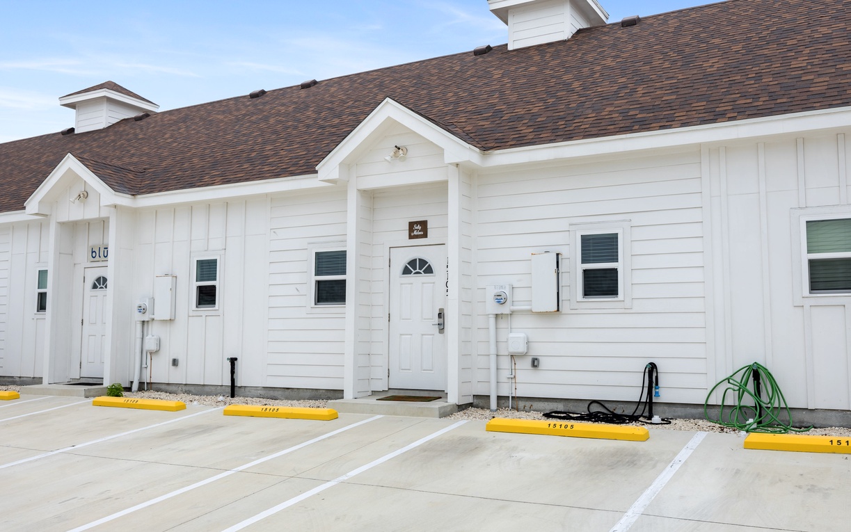 Modern white duplex units with convenient parking spaces right at your doorstep for easy arrival and departure.