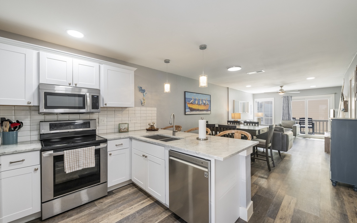 Your modern kitchen welcomes you with sleek white cabinets, granite countertops, and stainless steel appliances that make meal prep effortless.