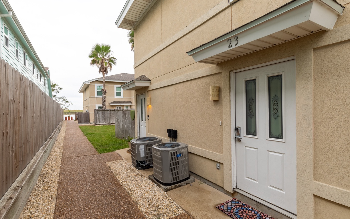 Modern two-story home in quiet residential neighborhood with covered entry and mature palm trees nearby.