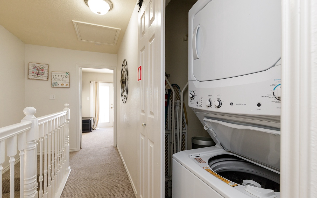 Your own washer and dryer make longer stays effortless, tucked conveniently in this bright hallway for easy access.