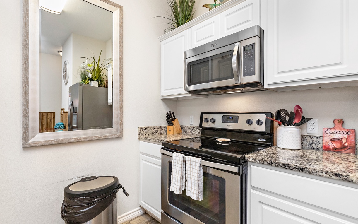 Your fully equipped kitchen awaits with granite counters, stainless appliances, and thoughtful touches like fresh plants to inspire your culinary adventures.