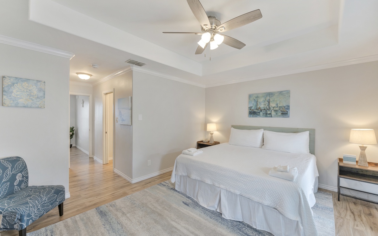Drift off to sleep in your serene bedroom, where soft lighting and coastal artwork create a peaceful retreat perfect for restful nights.