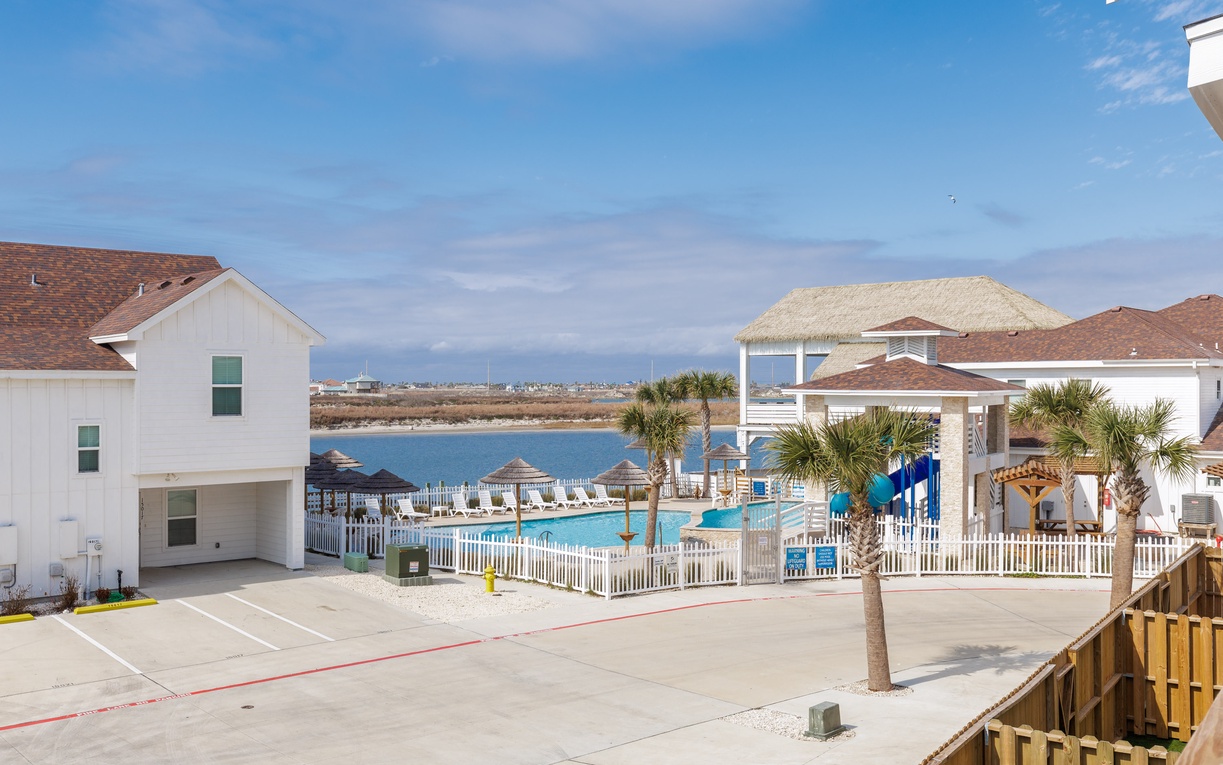 Beachfront resort community featuring swimming pool, tiki bar, and direct water access with rental homes.