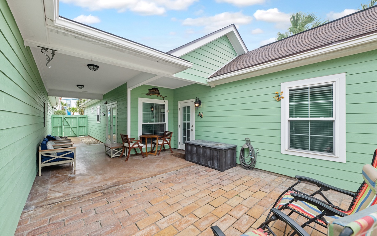Relax on your private patio with brick pavers and outdoor seating under tropical skies.