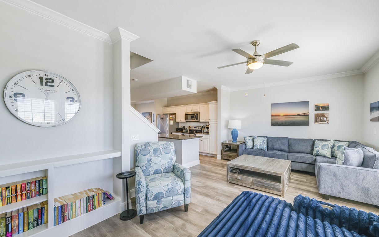 Relax in your bright, open living space with coastal décor, built-in library, and seamless flow to the kitchen.