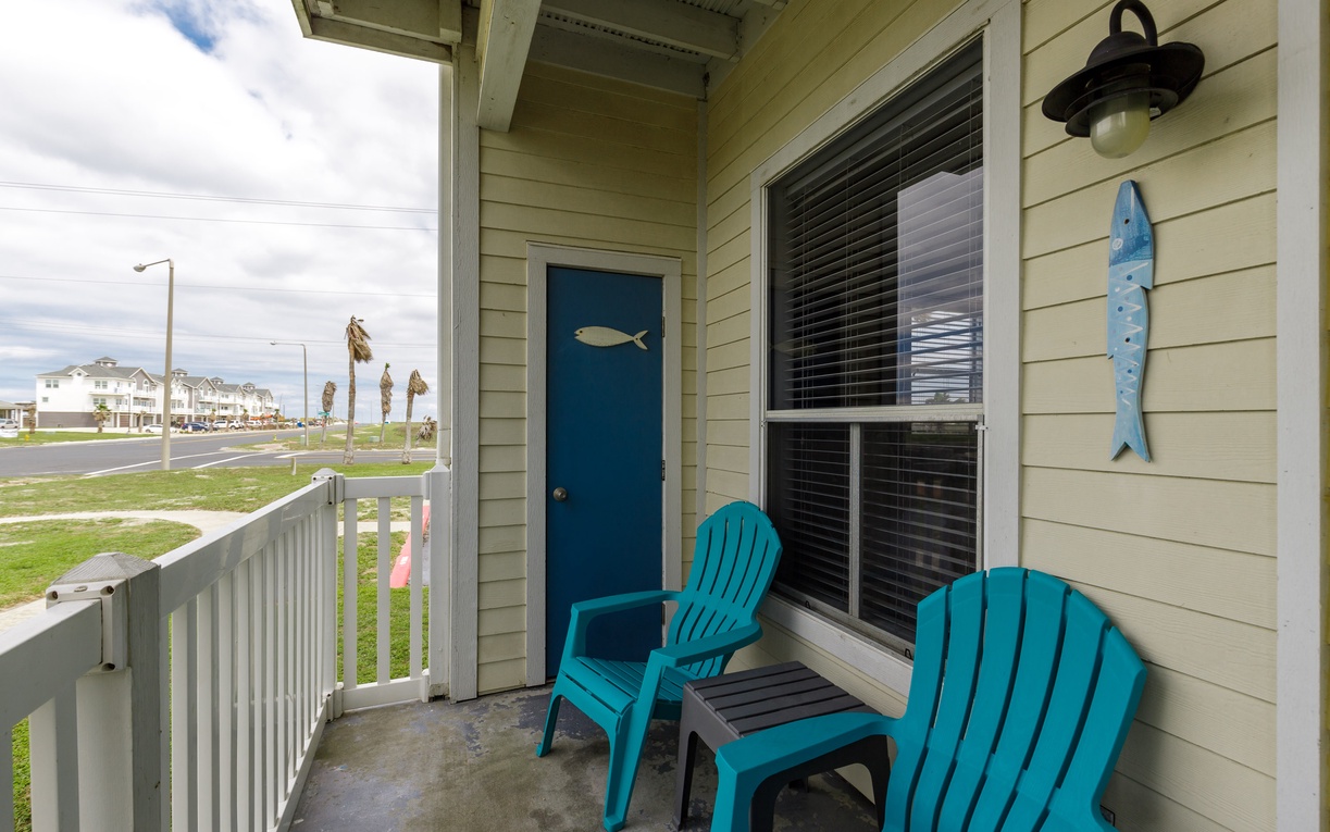 Relax on your private covered balcony with comfortable seating and charming coastal decor.