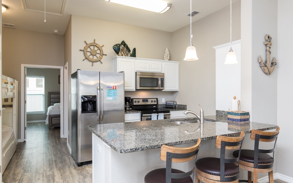 Your fully equipped kitchen awaits with granite counters, stainless appliances, and a breakfast bar perfect for morning coffee together.