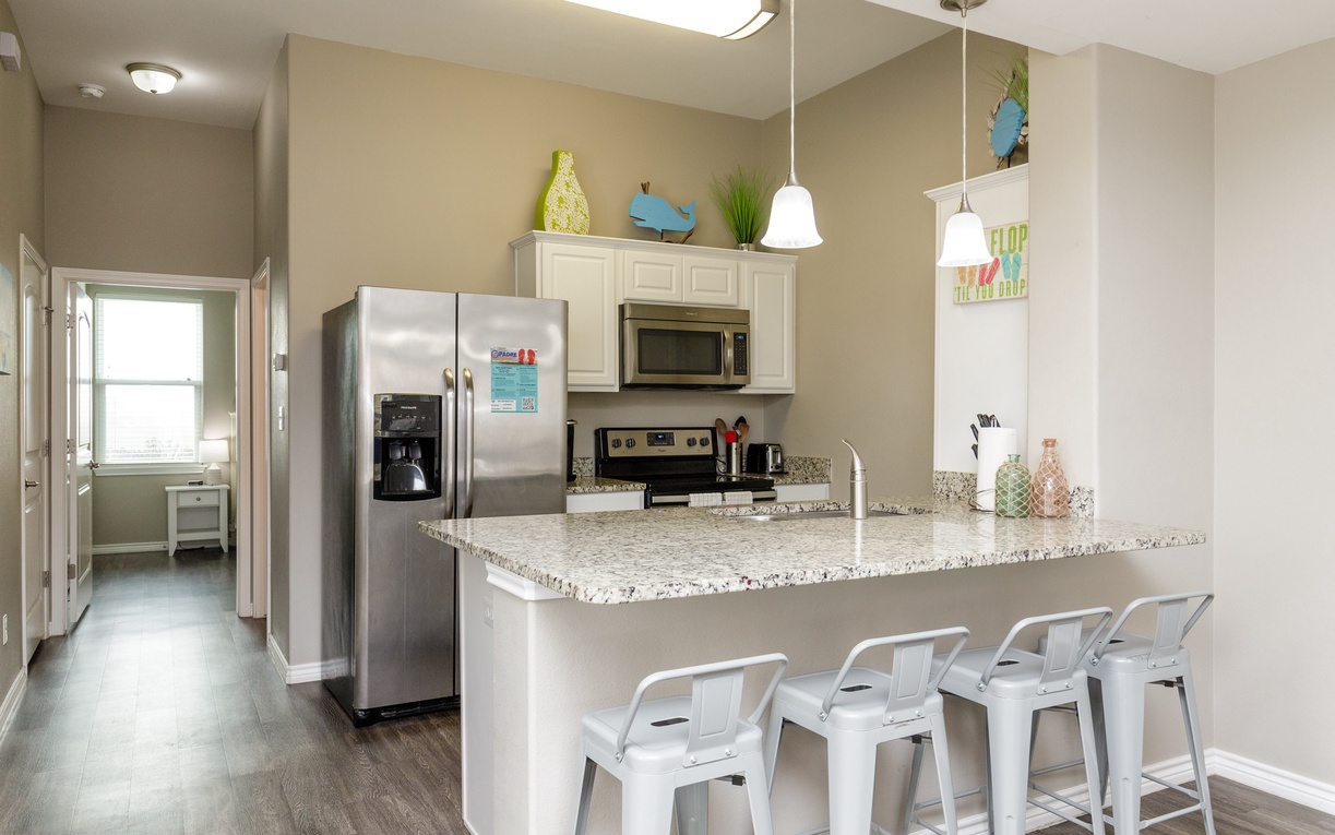 Your bright open kitchen features granite countertops, stainless steel appliances, and a breakfast bar perfect for morning coffee or casual meals.