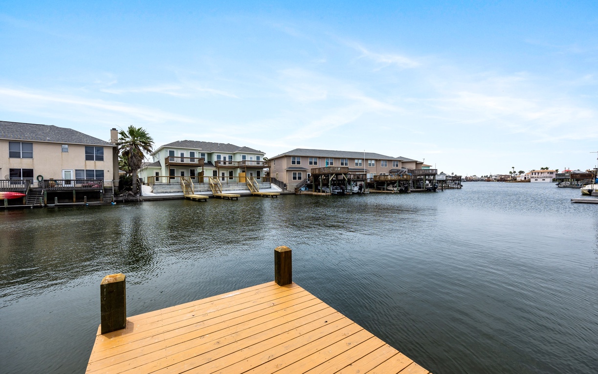 Waterfront property with private dock on calm canal waters, surrounded by peaceful residential community.