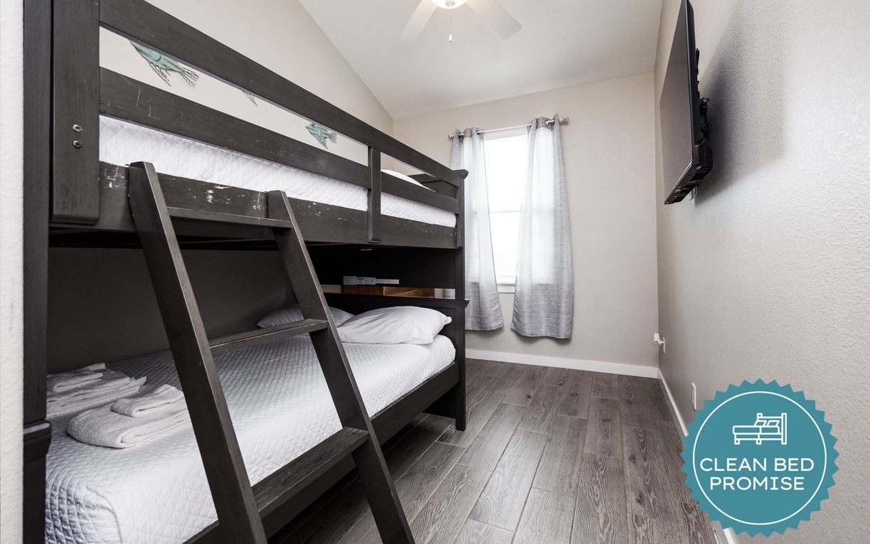 Your cozy bunk room features comfortable beds and entertainment, perfect for kids or groups sharing memorable vacation moments together.