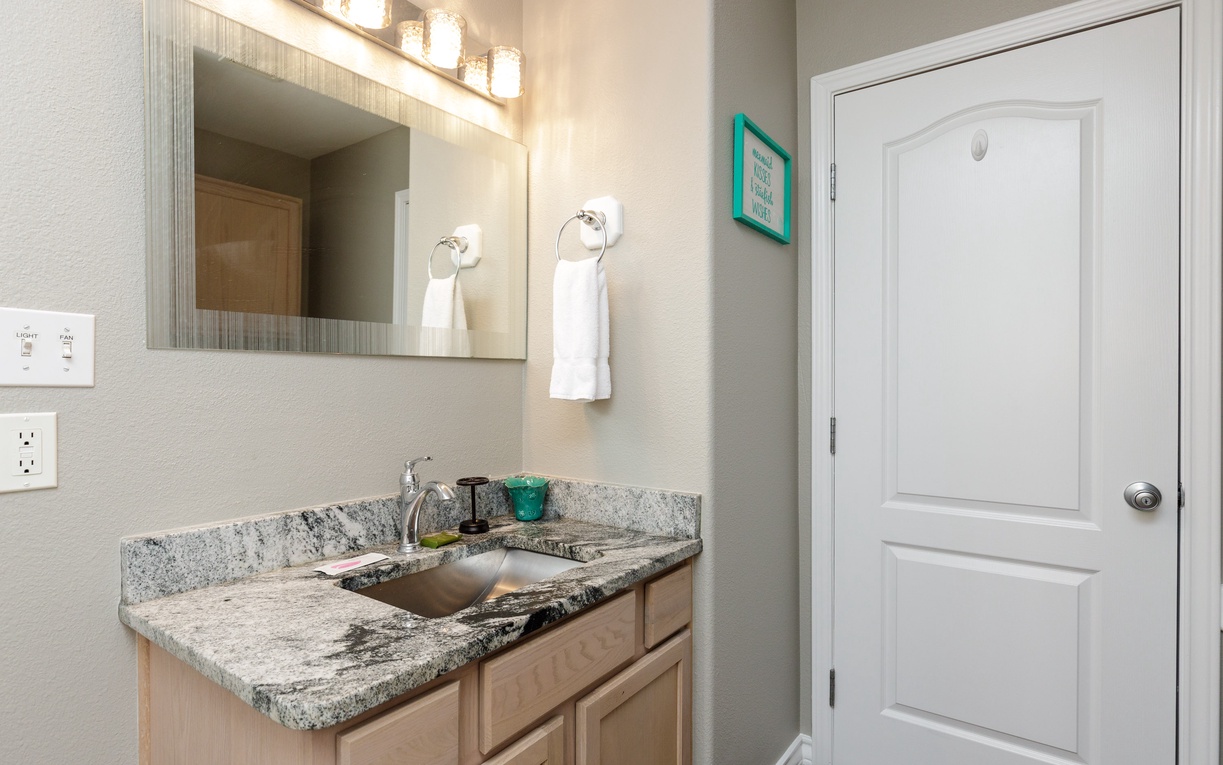 Step into your elegant bathroom featuring granite counters, warm lighting, and fresh towels waiting for your arrival.