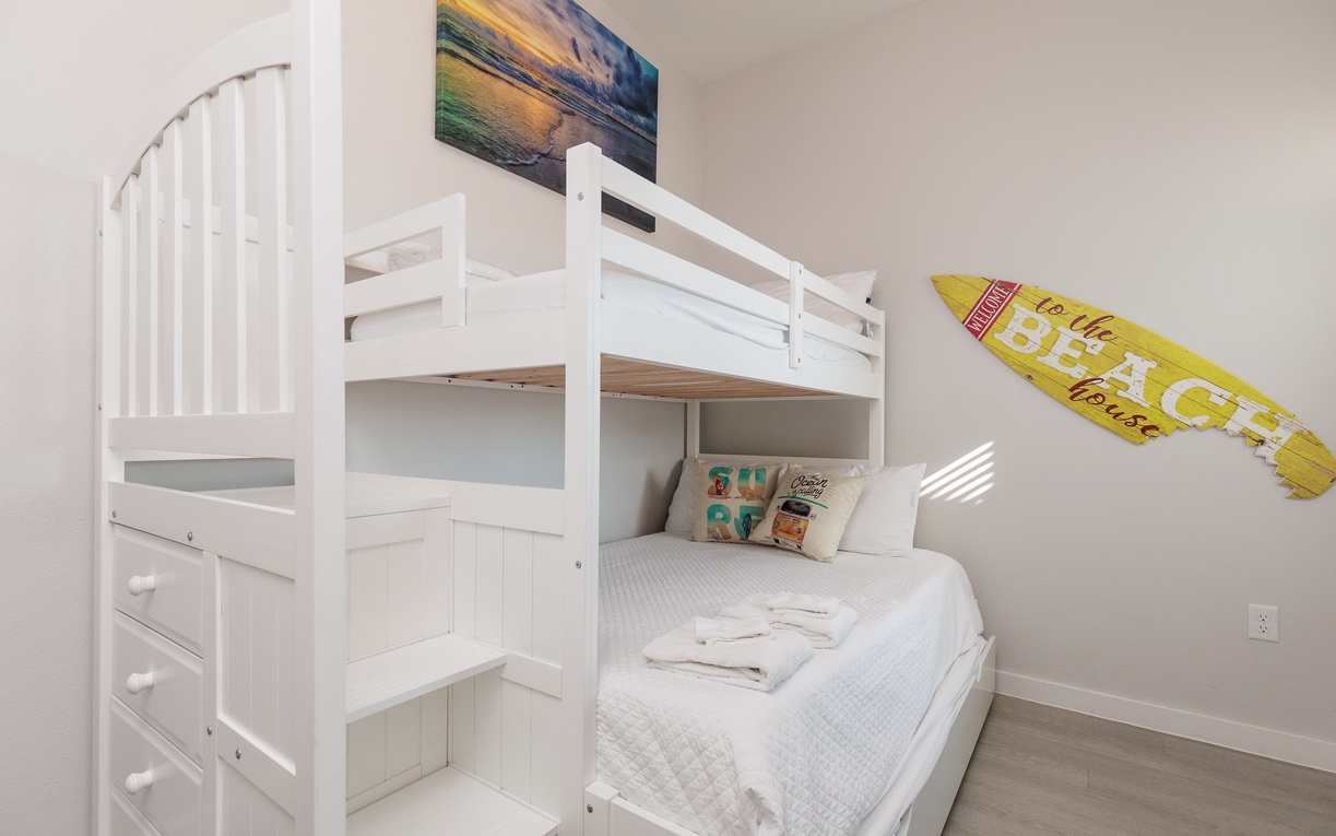 Your kids will love this cozy bunk bed room with beach-themed artwork and fresh towels waiting for their arrival.