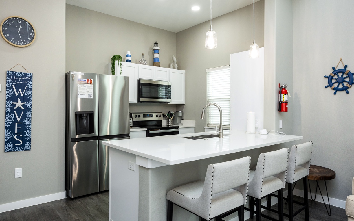 Gather around your bright modern kitchen with gleaming granite counters, stylish pendant lighting, and comfortable bar seating perfect for morning coffee or evening conversations.