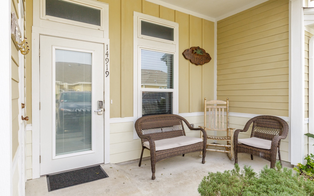 Step onto your private covered porch, where wicker seating awaits your morning coffee and evening relaxation in peaceful comfort.