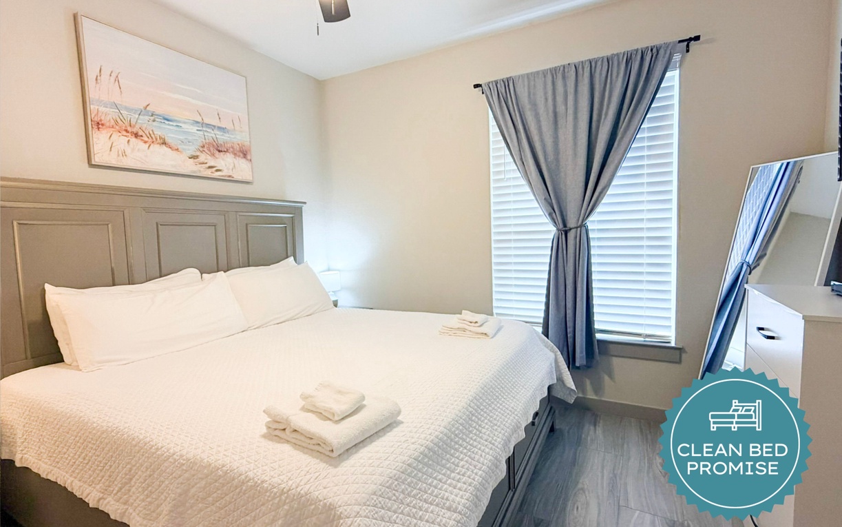 Sink into comfort with crisp white linens and coastal artwork creating your peaceful retreat with natural light.