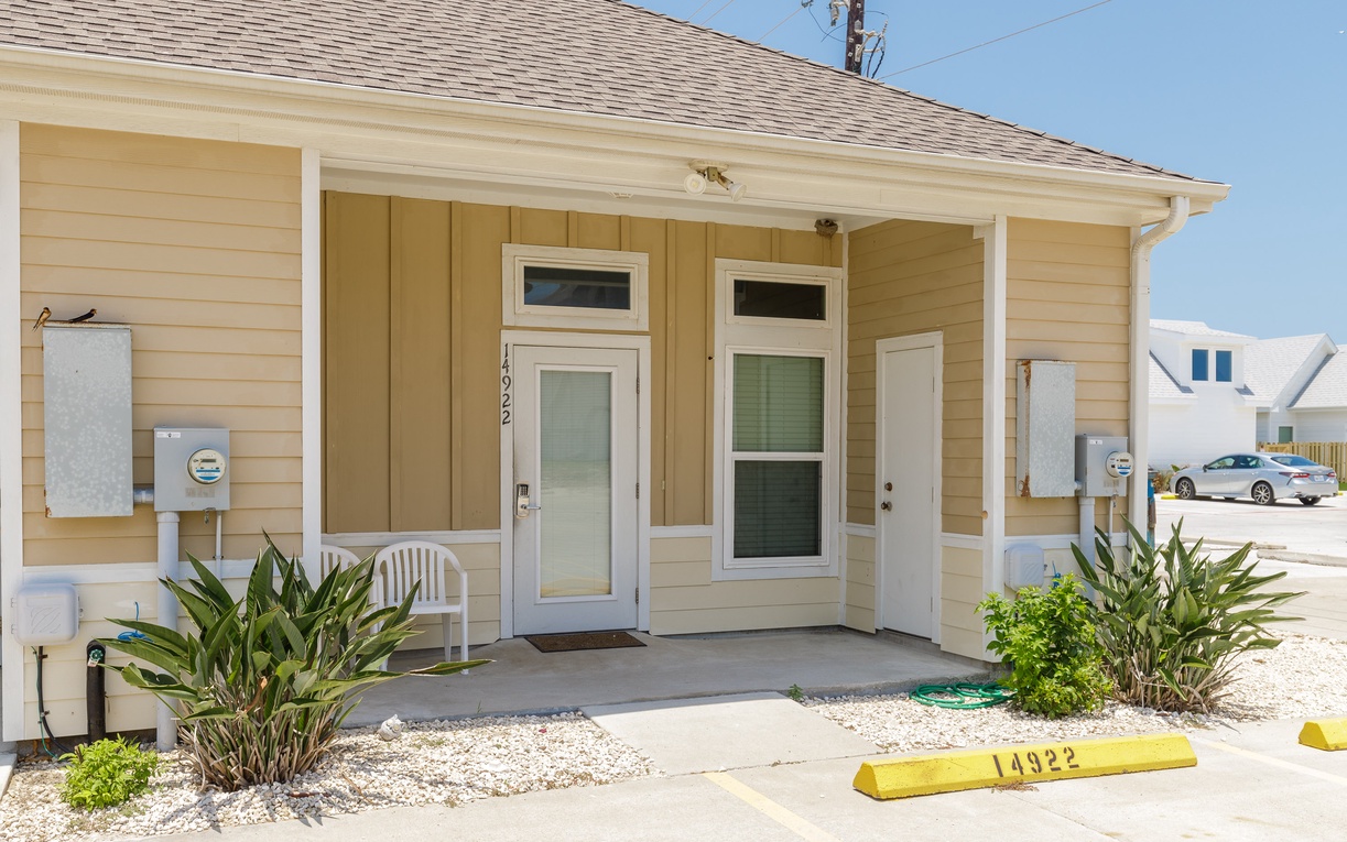 Welcoming beachside cottage with tropical landscaping and convenient covered entrance in a quiet coastal neighborhood.