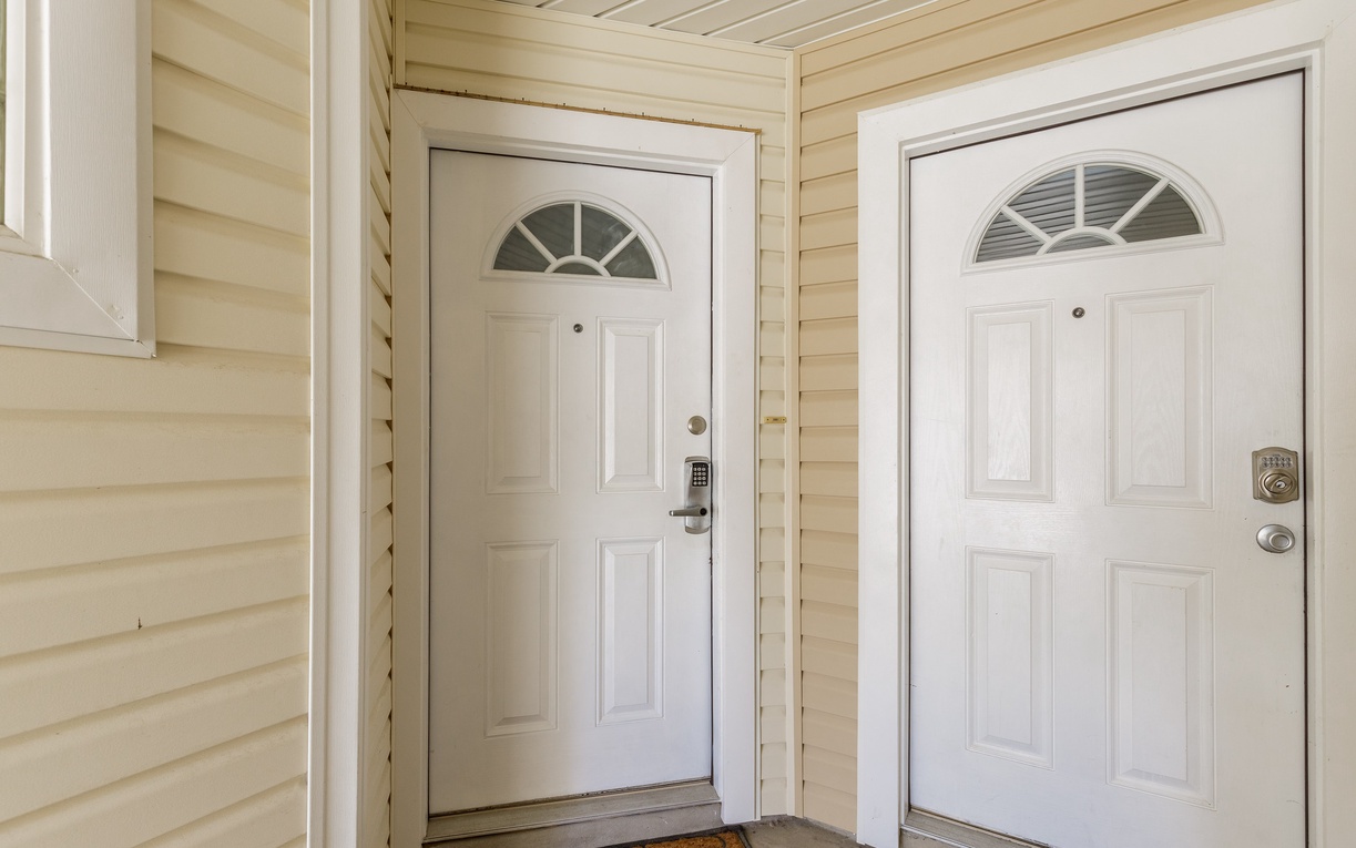 Clean white entrance doors with elegant arched windows welcome you to your comfortable vacation home.