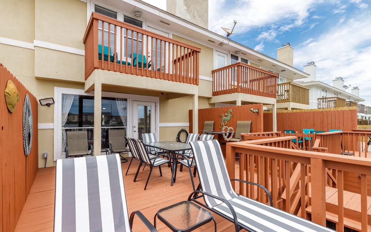 Your spacious deck awaits with comfy lounge chairs and dining table—perfect for morning coffee or sunset dinners overlooking the neighborhood.