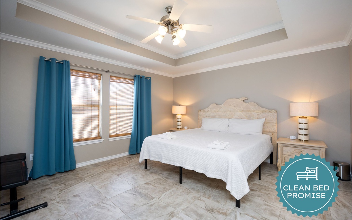 Unwind in your serene bedroom featuring a plush queen bed, elegant tray ceiling with ceiling fan, and tranquil blue accents throughout.