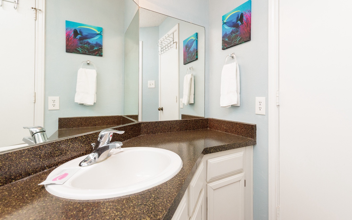 Freshen up in your bright, well-appointed bathroom with granite countertops, fresh towels, and cheerful ocean-themed artwork.