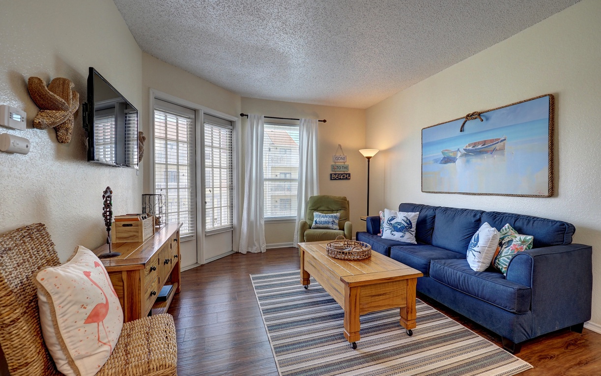 Sink into the plush navy sofa and let ocean artwork transport your thoughts to seaside adventures in this bright coastal living room.